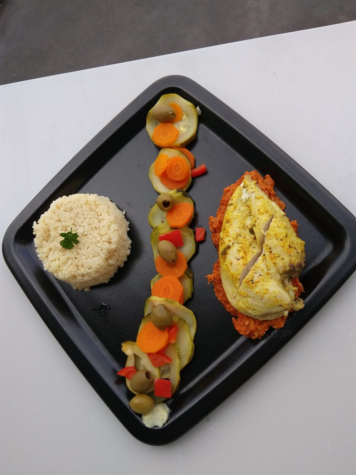 Suprêmes de poulet mariné citron curry accompagnés de petits légumes et olives vertes